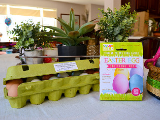 A carton of eggs with a box of Color Kitchen Natural Egg Dye Kit
