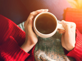 Woman drinking herbal tea in a sweater.